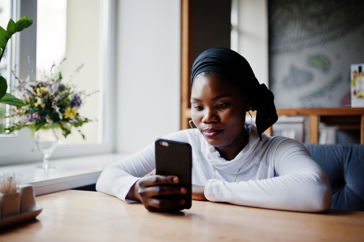 african-muslim-girl-black-hijab-sitting-cafe-with-mobile-phone-hand-1
